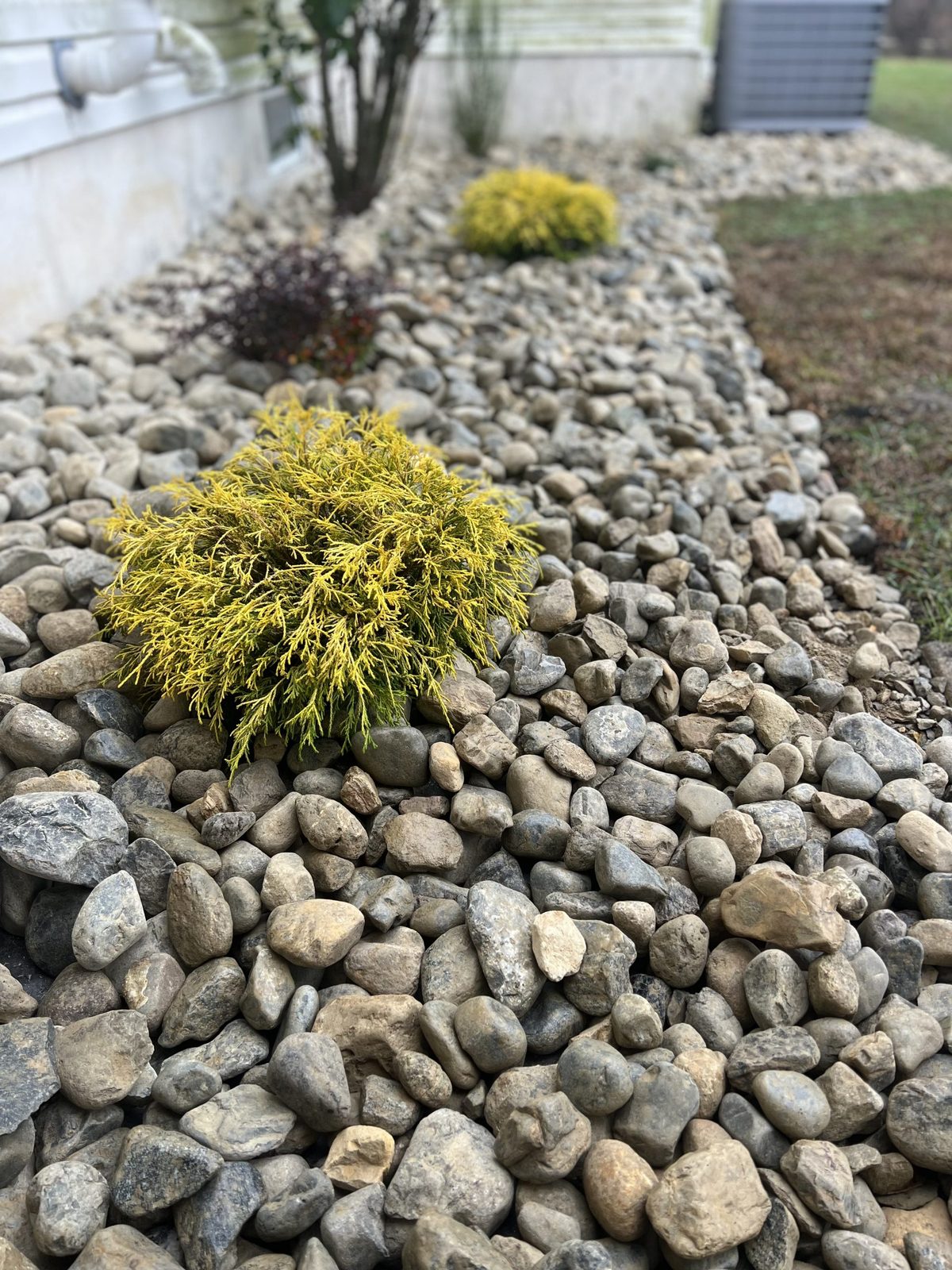 Boulder accents in a planted landscape bed